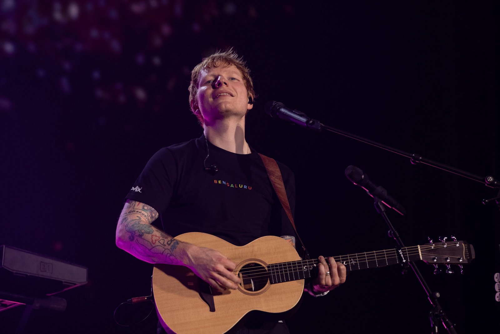 Ed Sheeran performing with guitar during his India tour